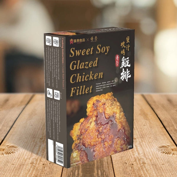 A box of chicken fillets in sweet soy sauce stands on a wooden surface reminiscent of Taiwanese night market fare. The front of the box has a close-up image of a chicken fillet.